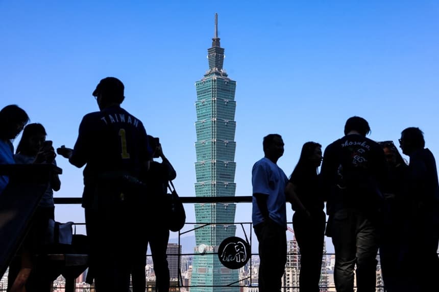 La gente se reúne en un mirador con el emblemático edificio Taipei 101 como telón de fondo en Taipéi, el 14 de enero de 2026. (I-Hwa Cheng/AFP vía Getty Images)