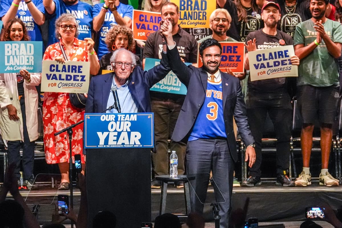 El alcalde de Nueva York, Zohran Mamdani (Der.) en el escenario junto al senador Bernie Sanders (I-Vt.) en un mitin para fomentar la participación electoral previo a las elecciones primarias de Nueva York en el distrito de Brooklyn, Nueva York, el 18 de junio de 2026. (Ryan Murphy/AP.)