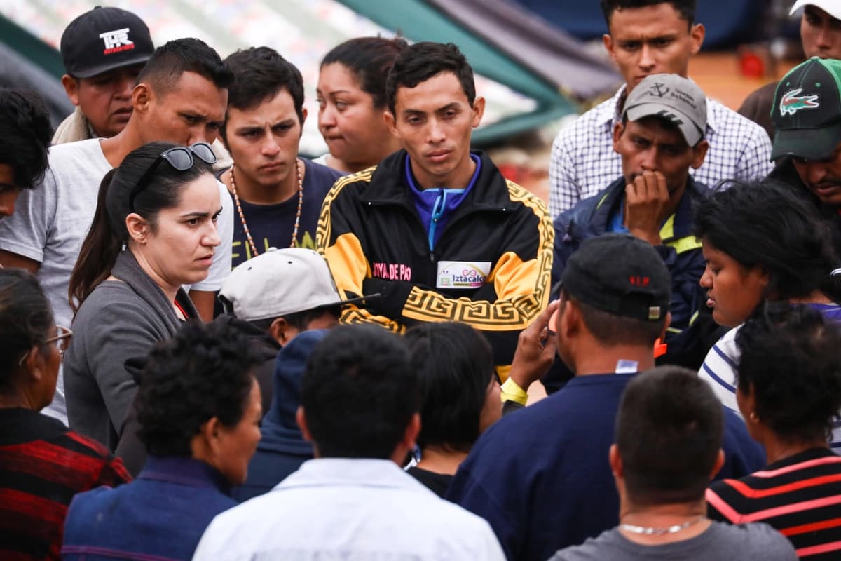 Miembros de la caravana de migrantes centroamericanos escuchan a Erika Pinheiro, directora de litigios de Al Otro Lado, quien les explica el proceso de asilo en Estados Unidos en un complejo deportivo municipal en la Zona Norte, cerca de la frontera entre Estados Unidos y México, en Tijuana, el 19 de noviembre de 2018. (Charlotte Cuthbertson/The Epoch Times).