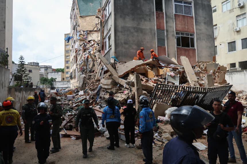 Personas y rescatistas trabajan entre los escombros de un edificio en la avenida Los Próceres tras el terremoto de magnitud 7.2 que sacudió a Venezuela y otras zonas del Caribe el 25 de junio de 2026, en Caracas, Venezuela. Según las autoridades, el sismo dejó 164 muertos y más de 970 heridos. (Edilzon Gamez/Getty Images).