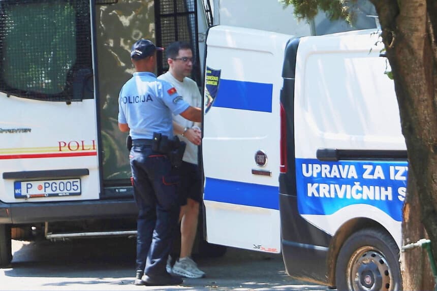 Un agente de policía escolta a un ciudadano iraní, sospechoso de ataques informáticos que dañaron la infraestructura estadounidense por valor de 3.400 millones de dólares, en Podgorica, Montenegro, el 26 de junio de 2026. (Stevo Vasiljevic/Reuters).