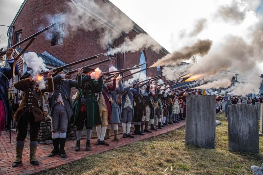 Recreadores de la Guerra de Independencia disparan salvas en la Capilla de San Agustín al inicio de las ceremonias del Día de la Evacuación en Boston, el 17 de marzo de 2026. (Joseph Prezioso/AFP vía Getty Images)