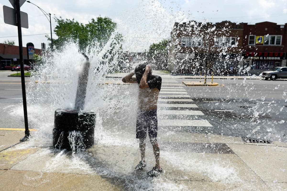 Una persona se refresca con agua de una boca de incendios abierta durante una ola de calor en el lado oeste de Chicago el 2 de julio de 2026. (Octavio Jones/AFP vía Getty Images).