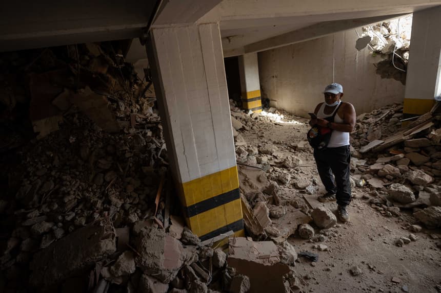 Una persona busca en medio de los escombros de un edificio este domingo, en La Guaira, Venezuela. (EFE/ Ronald Peña R)