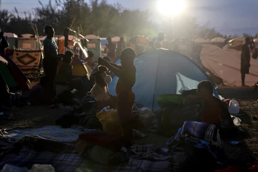 Un niño juega con un perro de peluche en un campamento de migrantes, el 21 de septiembre de 2021. (John Moore/Getty Images).
