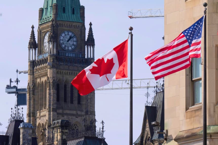 Se ven banderas de Canadá y Estados Unidos ondeando cerca de Parliament Hill, el 22 de marzo de 2023, en Ottawa. (The Canadian Press/Adrian Wyld).