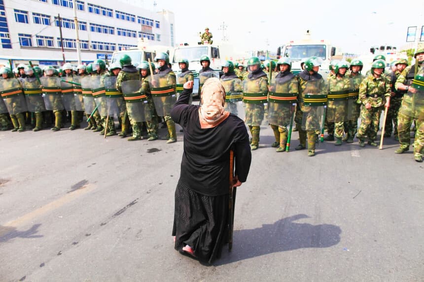 Una mujer uigur protesta frente a la policía en una calle de Urumqi, la capital de Xinjiang, el 7 de julio de 2009. (Guang Niu/Getty Images).