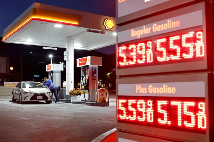 Un cliente lava el parabrisas de su auto cerca de los letreros con los precios de la gasolina en una estación de servicio de Pasadena, California, el 7 de julio de 2026. (Mario Tama/Getty Images)