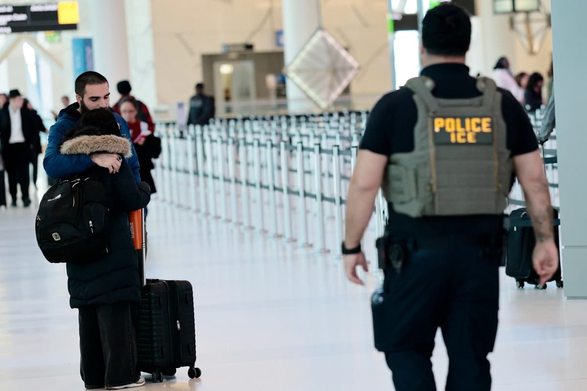 Una pareja se abraza mientras agentes del Servicio de Inmigración y Control de Aduanas (ICE) patrullan la Terminal C del Aeropuerto LaGuardia en Nueva York el 24 de marzo de 2026. (Michael M. Santiago/Getty Images)