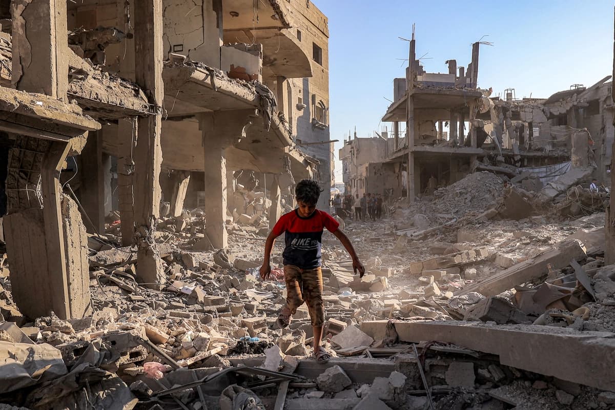 Un niño camina entre los escombros de un edificio destruido por un bombardeo israelí tras una orden de evacuación en el campamento de refugiados de Maghazi, en el centro de la Franja de Gaza, el 12 de junio de 2026. (Eyad Baba/AFP vía Getty Images).