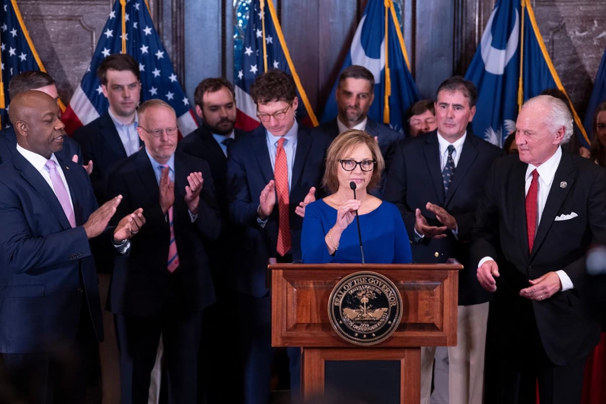 La recién nombrada senadora interina de Estados Unidos, Darline Graham Nordone, junto al gobernador de Carolina del Sur, Henry McMaster (derecha), y el senador Tim Scott (republicano por Carolina del Sur) (izquierda), habla con miembros de la prensa tras ser designada para cubrir la vacante dejada por el fallecimiento de su hermano, el senador Lindsey Graham, en el capitolio estatal en Columbia, Carolina del Sur, el 13 de julio de 2026. (Foto AP/Sean Rayford).