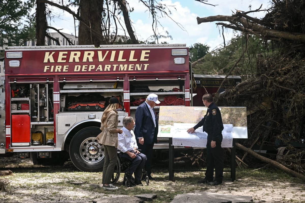 El presidente Donald Trump, el gobernador de Texas, Greg Abbott (segundo por la izquierda), y la primera dama Melania Trump (izquierda) se reúnen con funcionarios locales y personal de emergencia cerca del río Guadalupe tras las devastadoras inundaciones ocurridas en la zona durante el fin de semana del 4 de julio, en Kerrville, Texas, el 11 de julio de 2025. (Brendan Smialowski/AFP vía Getty Images).