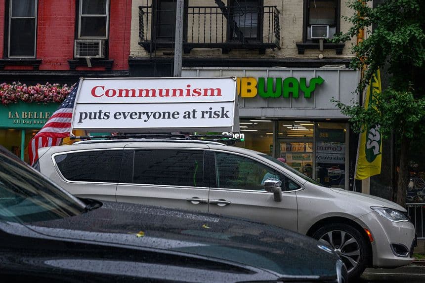 Un automóvil circula con una pancarta en la que se lee "El comunismo pone a todo el mundo en peligro" cerca de una manifestación contra el Partido Comunista de China (PCCh), bajo la lluvia, frente a la 80.ª sesión de la Asamblea General de las Naciones Unidas (AGNU), el 25 de septiembre de 2025 en la ciudad de Nueva York. (Alexi J. Rosenfeld/Getty Images)