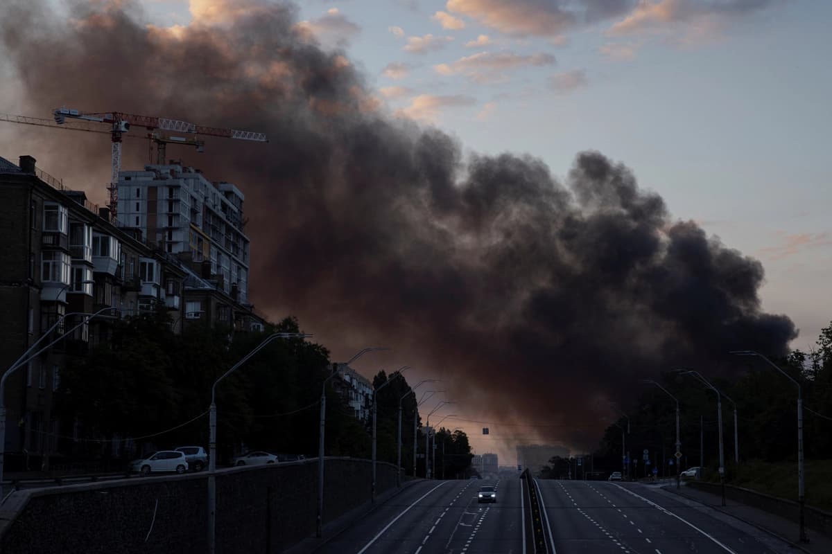 Una columna de humo se eleva sobre la ciudad mientras un automóvil circula por una autopista tras los ataques con misiles rusos, en el marco del ataque de Rusia contra Ucrania, en Kiev, Ucrania, 19 de julio de 2026. (Thomas Peter/Reuters)