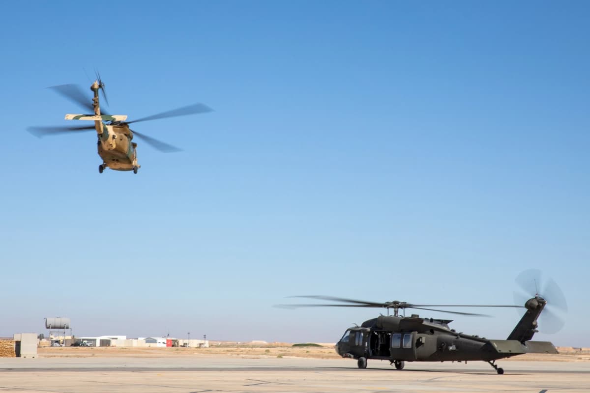 Un helicóptero UH-60L Blackhawk de las Fuerzas Armadas de Jordania despega mientras un helicóptero UH-60 Blackhawk del Ejército de EE. UU. se prepara para levantar vuelo durante el ejercicio Eager Lion 2024 en la Base Aérea Muwaffaq Salti, en Jordania, el 16 de mayo de 2024. (Foto del Ejército de EE. UU. tomada por la soldado de primera clase Nataja Ford)