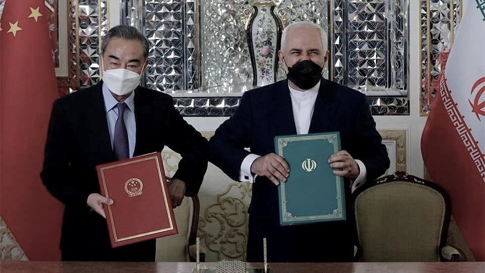El entonces ministro de Relaciones Exteriores de Irán, Mohammad Javad Zarif (a la derecha), y su homólogo chino, Wang Yi, posan para una foto tras firmar un acuerdo en Teherán, Irán, el 27 de marzo de 2021. (AFP vía Getty Images)