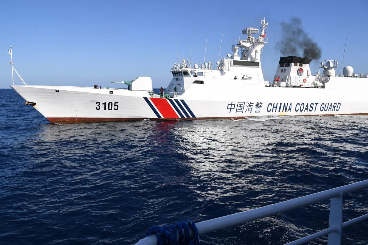 Un barco de la guardia costera china sigue de cerca al buque BRP Datu Tamblot, de la Oficina de Pesca y Recursos Acuáticos de Filipinas (BFAR), cerca del banco de Scarborough, controlado por China, en aguas en disputa del Mar de China del Sur, el 15 de febrero de 2024. (Ted Aljibe/AFP vía Getty Images)