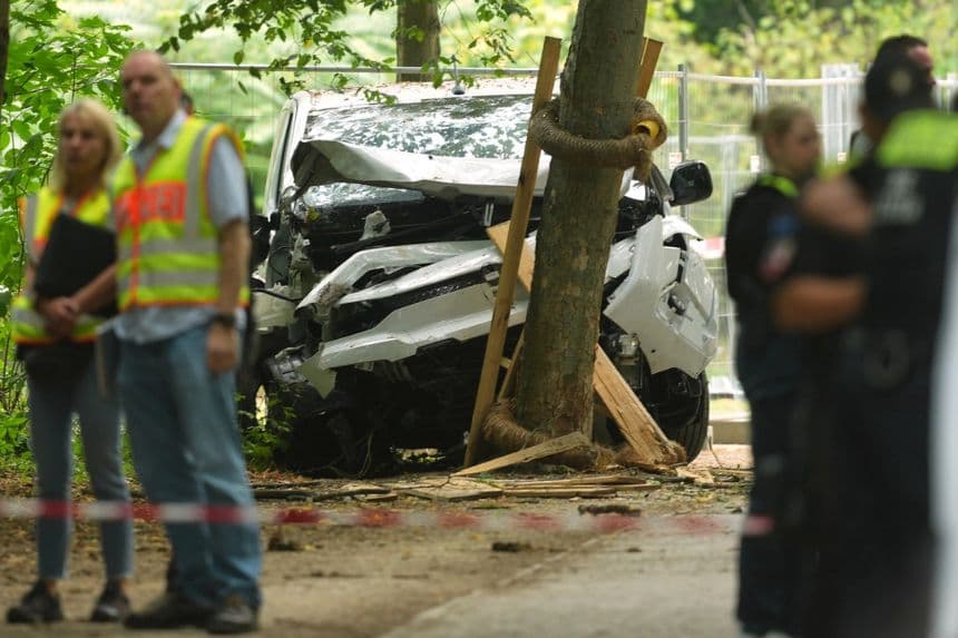 Agentes de policía permanecen cerca de un vehículo que se estrelló contra un árbol tras arrollar a una multitud cerca de un evento anual del Orgullo Gay, en Berlín, el 26 de julio de 2026. (Foto AP/Markus Schreiber)