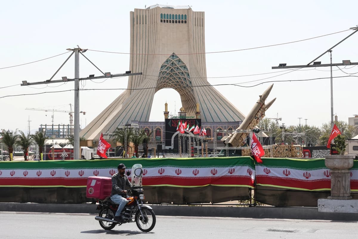 Un hombre pasa en bicicleta junto a misiles de fabricación iraní expuestos en la Plaza Azadi de Teherán el 24 de julio de 2026. (AFP vía Getty Images)