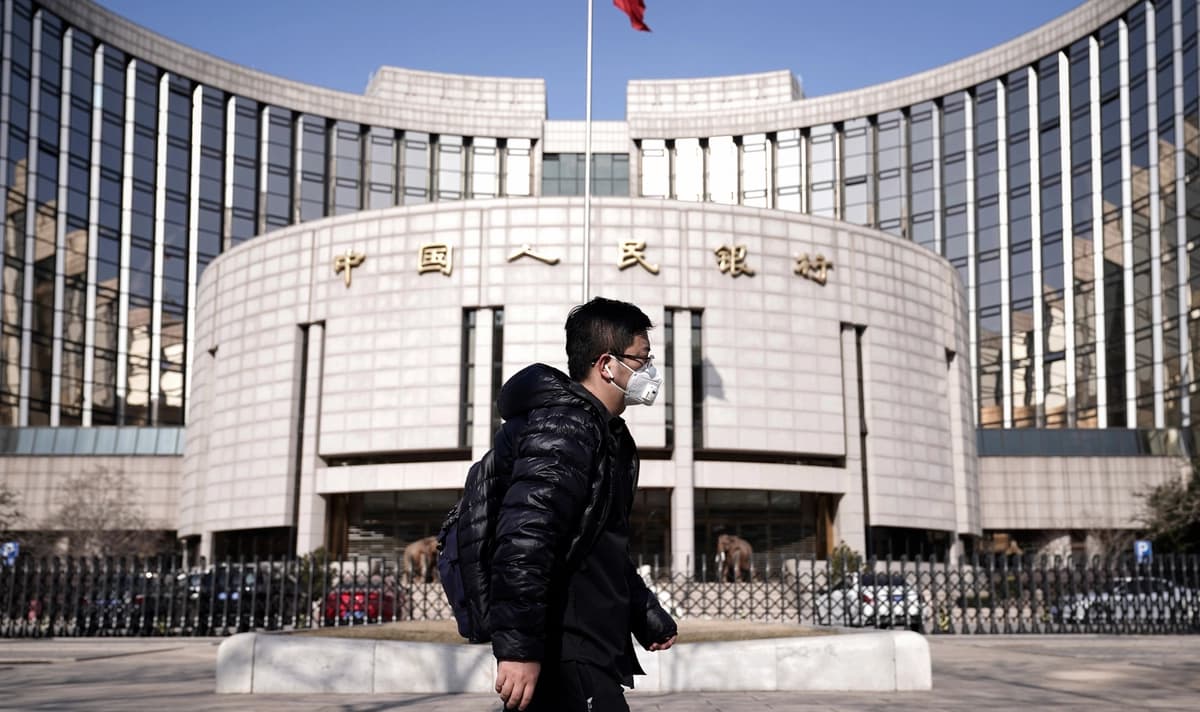 Un hombre con cubrebocas pasa frente a la sede del Banco Popular de China, el banco central, en Beijing, China, el 3 de febrero de 2020. (Jason Lee/Reuters)
