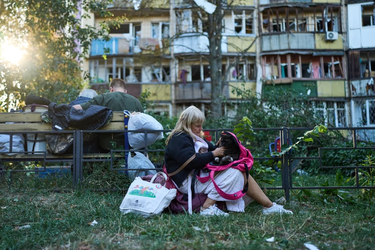 Residentes se sientan frente a edificios residenciales gravemente dañados tras un ataque ruso durante la noche, en Kiev, Ucrania, el 20 de agosto de 2026. (Francisco Seco/AP Photo)