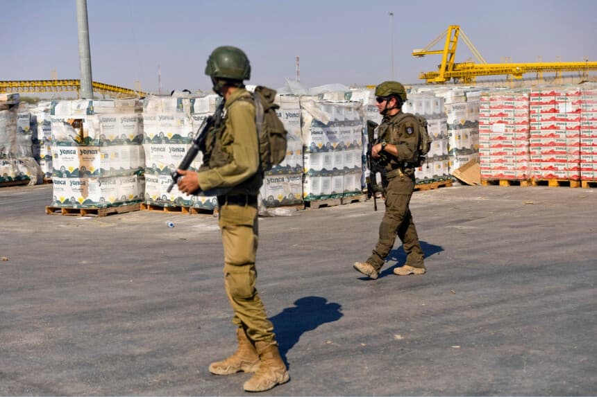 Soldados israelíes pasan junto a paquetes de ayuda humanitaria que esperan ser recogidos en el lado palestino del Punto de Paso de Kerem Shalom, en Kerem Shalom, Franja de Gaza, el 24 de julio de 2025. (Amir Levy/Getty Images)