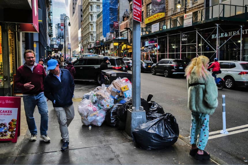 La gente pasa junto a un montón de bolsas de basura en el distrito de Manhattan, Nueva York, el 20 de marzo de 2024. (Charly Triballeau/AFP/Getty Images).