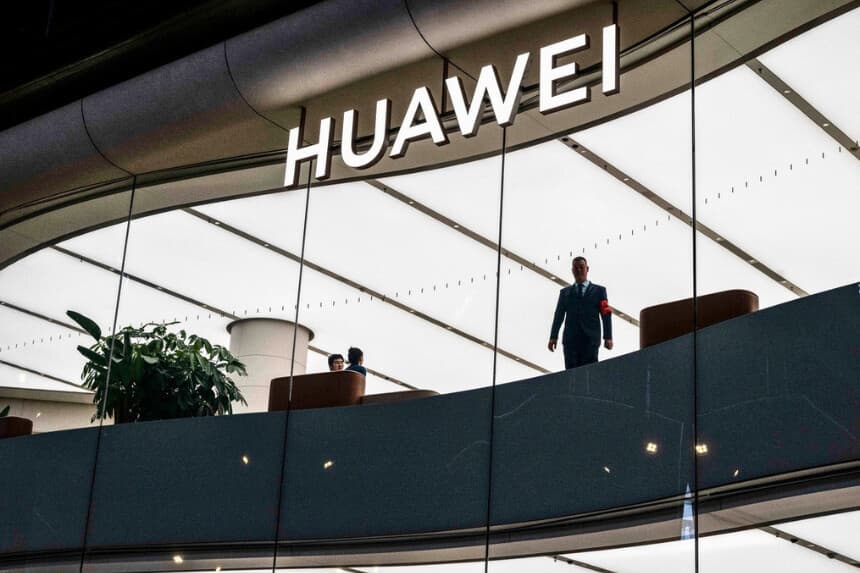 Un trabajador está de pie en el escaparate de una tienda Huawei en una zona comercial de Pekín el 5 de noviembre de 2024. (Foto de Kevin Frayer/Getty Images).