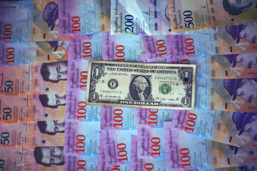 Esta ilustración muestra billetes de bolívar venezolano y un billete de un dólar estadounidense en Caracas el 28 de enero de 2019. (YURI CORTEZ/AFP vía Getty Images)