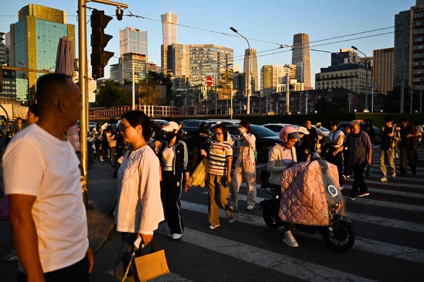 Unas personas cruzan una calle al atardecer en Pekín el 3 de septiembre de 2026. (Greg Baker/AFP vía Getty Images).