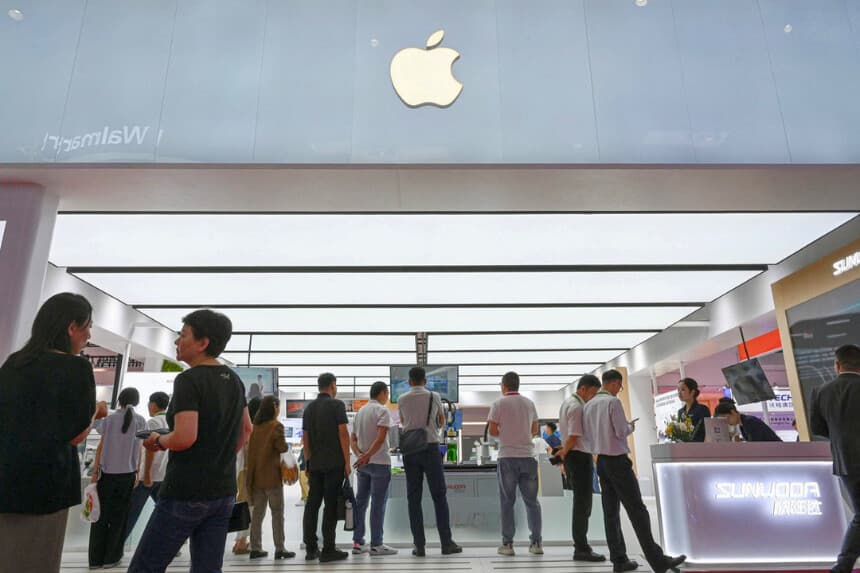 La gente pasa junto a un stand de APPLE y sus empresas proveedoras, incluyendo Sunwoda, JUSTECH e Innovation Group, durante la Expo Internacional de la Cadena de Suministro de China (CISCE) en Pekín el 17 de julio de 2025. (Jade Gao/AFP vía Getty Images).