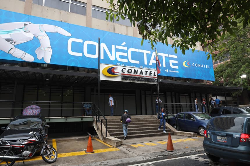 Personas caminan frente a la sede principal de la Comisión Nacional de Telecomunicaciones (CONATEL) este jueves en Caracas, Venezuela. La delegación opositora que dialoga con el chavismo saludó el levantamiento de las restricciones a varios sitios web de medios de comunicación que permanecieron bloqueados por años en Venezuela e instó a que la medida aplique para todos. (EFE/ Miguel Gutierrez)