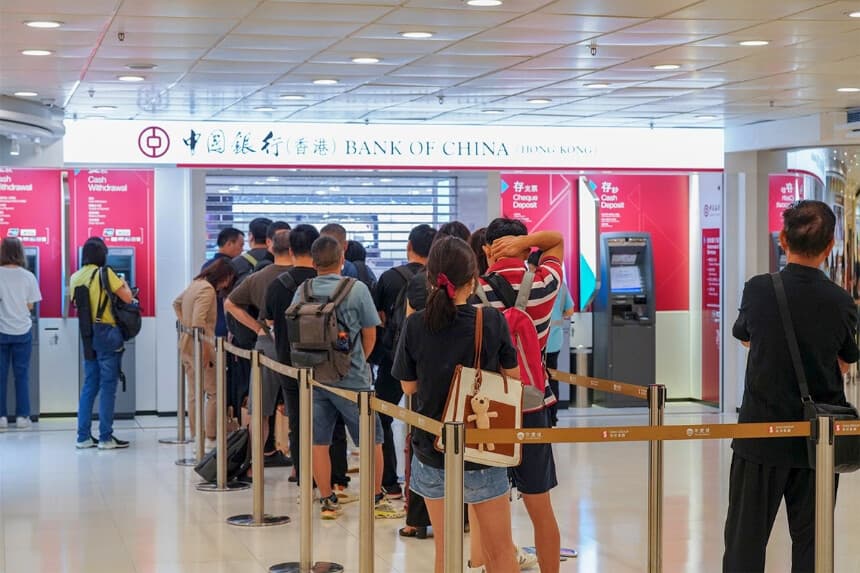 La gente hace fila para usar los cajeros automáticos en una sucursal del Banco de China. (The Epoch Times).